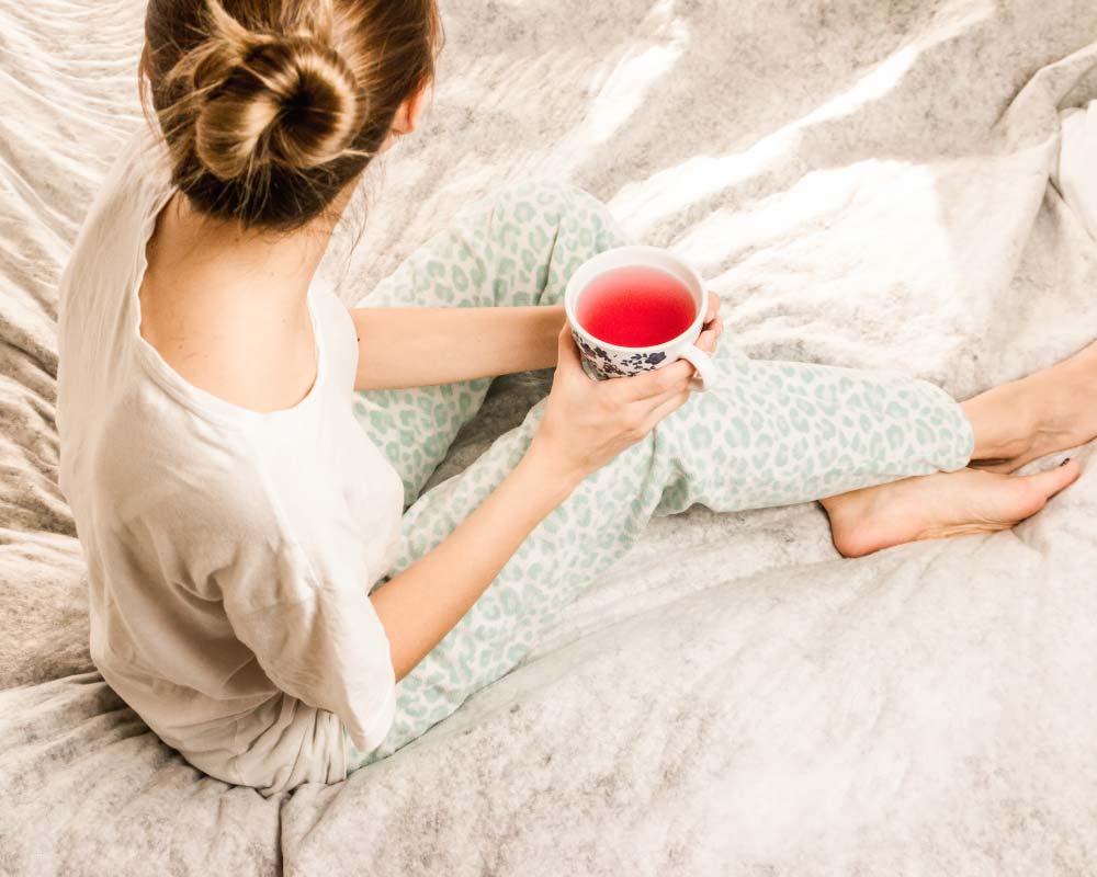 woman in bed drinking tea nightly routine