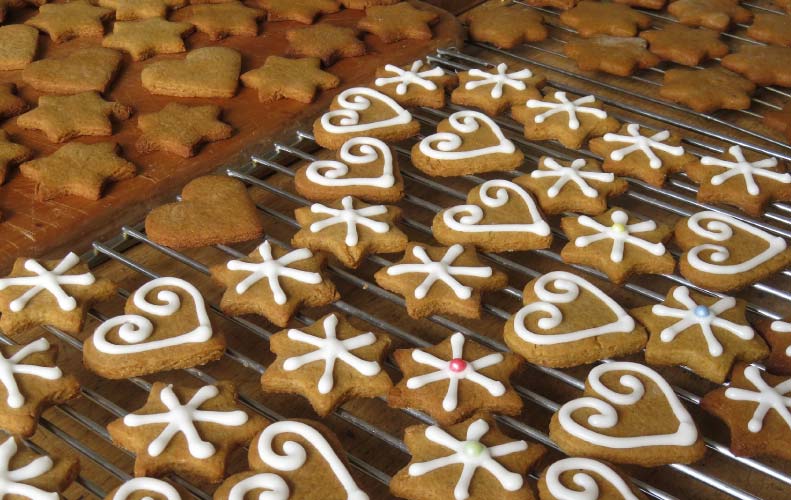 lightly frosted gingerbread cookies in holiday shapes including snowflakes and hearts