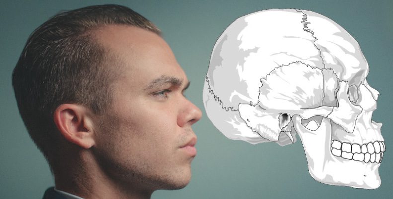 Side profile of brunette man in front of a teal wall next to a drawing of a skull depicting the temporomandibular joint