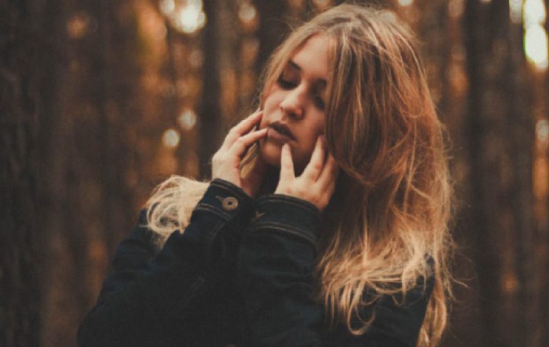 girl holding her jaw with both hands experiencing phantom tooth pain